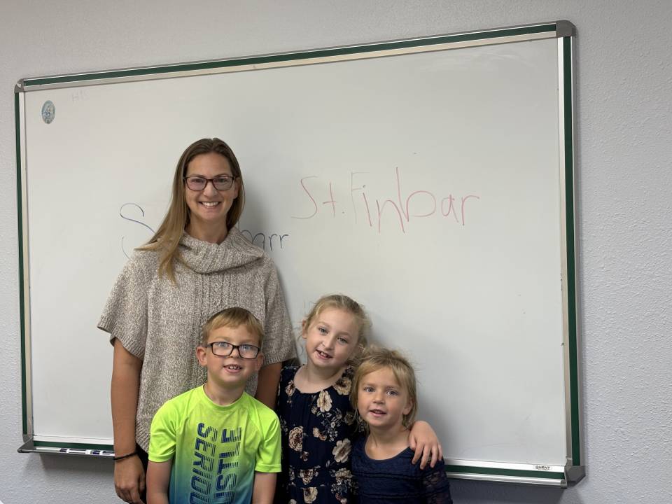 Rochelle Fay and children in front of a whiteboard.